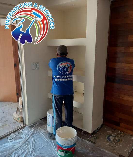 Pintor aplicando rodillo de forma uniforme en una pared de sala con iluminación natural perfecta